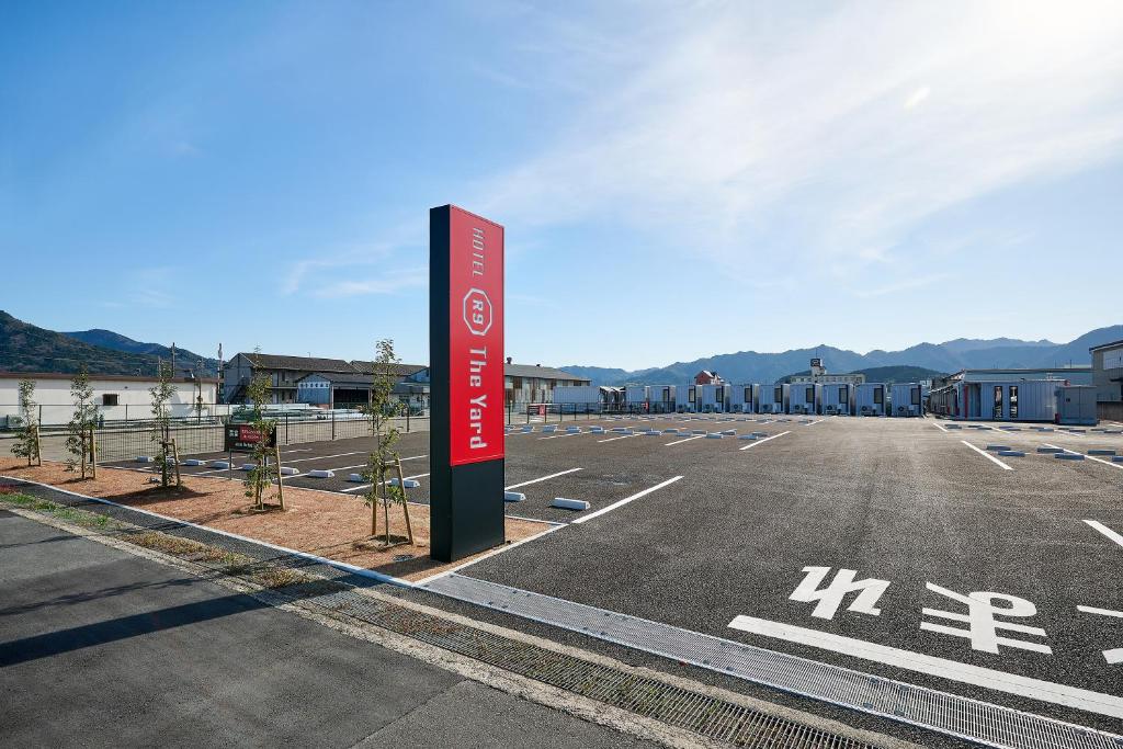 an empty parking lot with a sign in the middle at HOTEL R9 The Yard Tamba in Isō