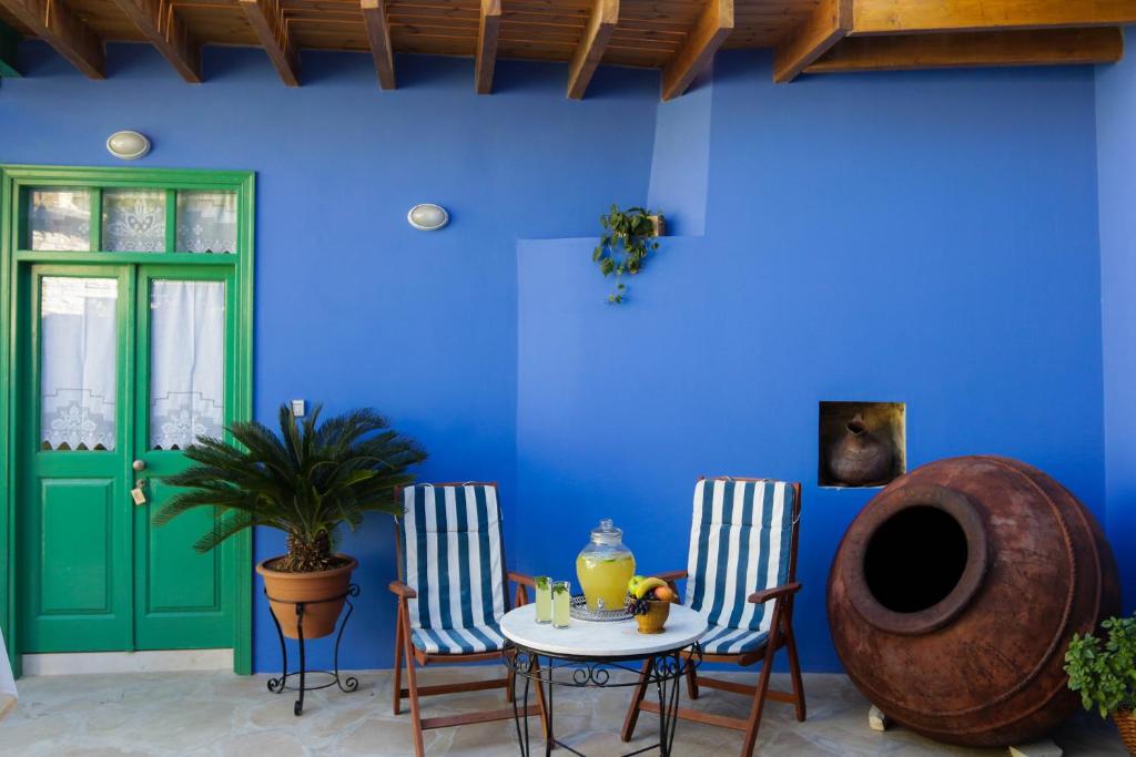 Habitación con mesa, 2 sillas y pared azul. en To Konatzi tis Marikas tzai tou Yianni, en Kato Drys