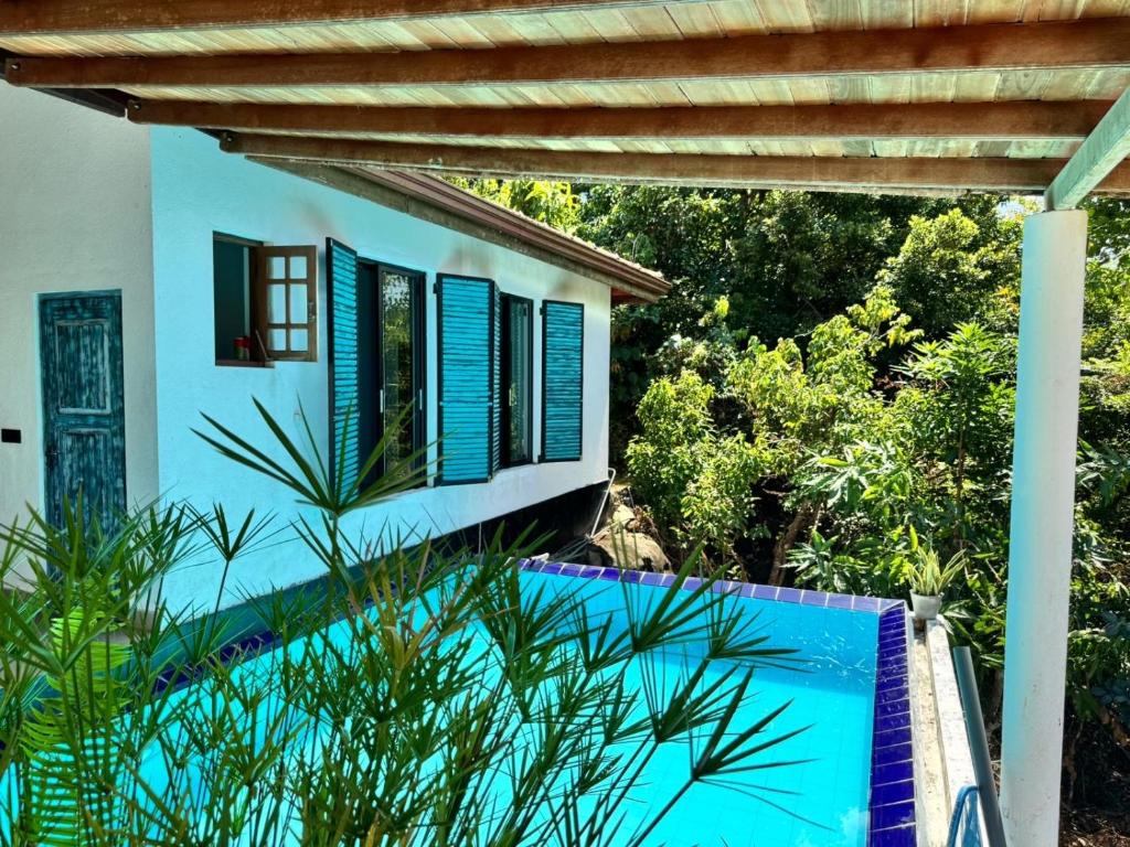 a house with blue shutters and a swimming pool at The Ellen Horizon in Ganegama South