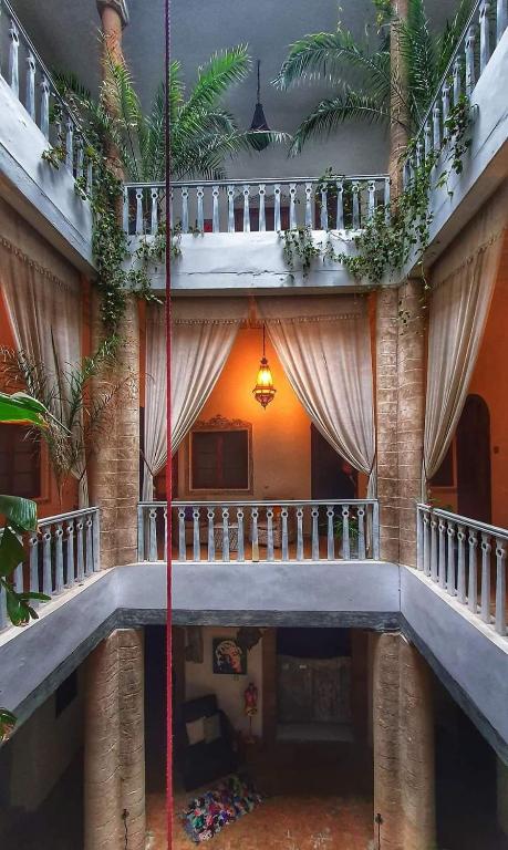 a building with a staircase with curtains and plants at Les Terrasses d'Essaouira - Yoga Studio in Essaouira
