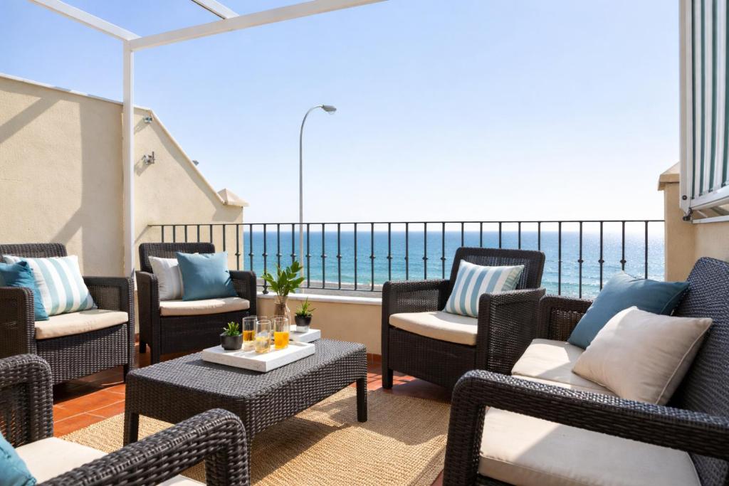 a balcony with chairs and tables and a view of the ocean at Brisa Chilches nº 5 in Málaga