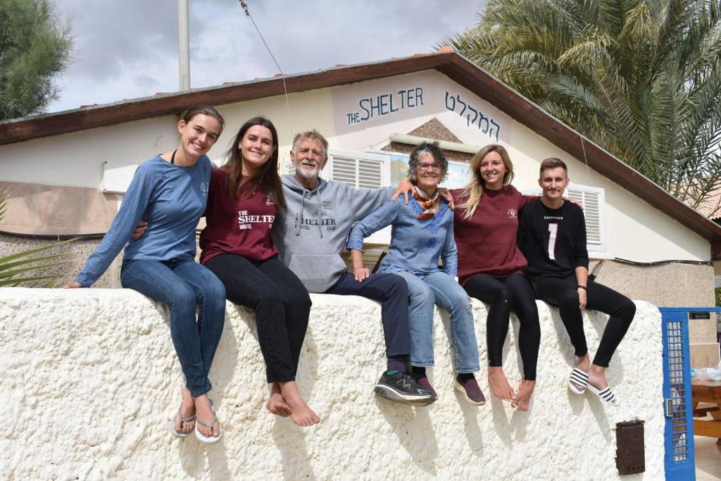 a group of people sitting on top of a wall at The Shelter Hostel Eilat in Eilat