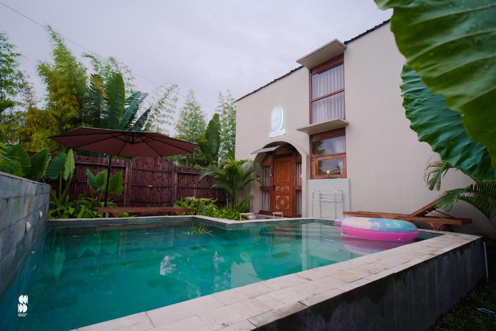 a swimming pool in front of a house at The Phalosaa Villa unit Family in Ngaglik