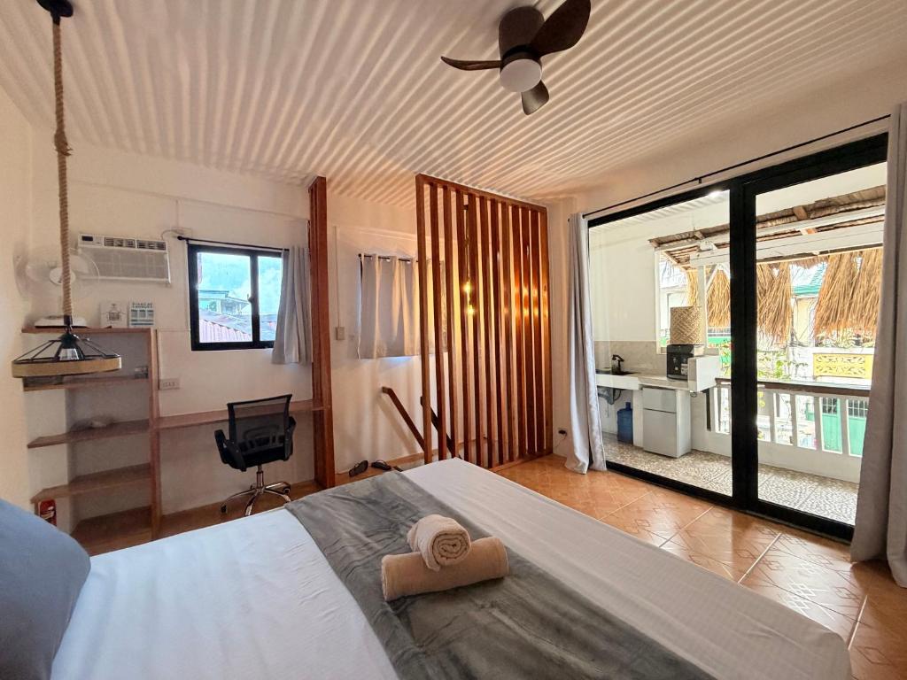 a bedroom with a bed and a ceiling fan at New Studio with Balcony , General Luna in General Luna