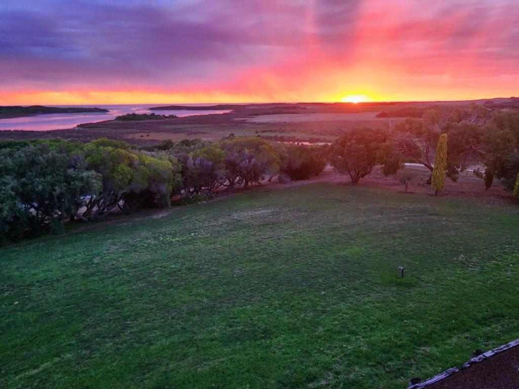 an aerial view of a field with the sunset in the background at Magic at the Mouth in Nelson