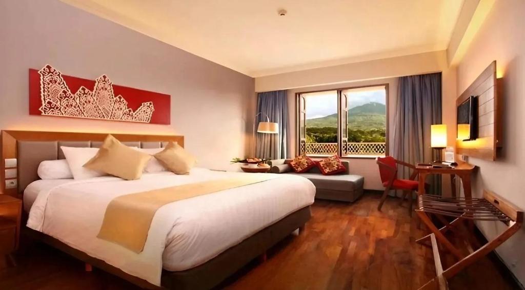 a bedroom with a large bed and a large window at Monopoli Hotel Bukittinggi in Bukittinggi