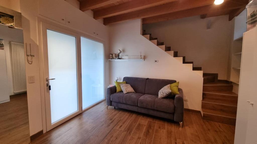 a living room with a couch and a staircase at Casetta gialla in Brianza - Monticello Brianza - NON E' CASATENOVO in Casatenovo
