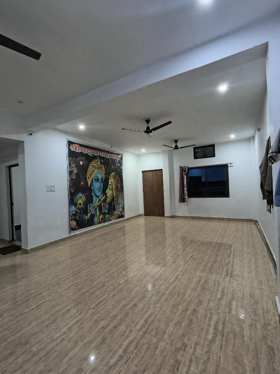 a room with a dance floor with a painting on the wall at Jai Krishna Guest House in Ayodhya