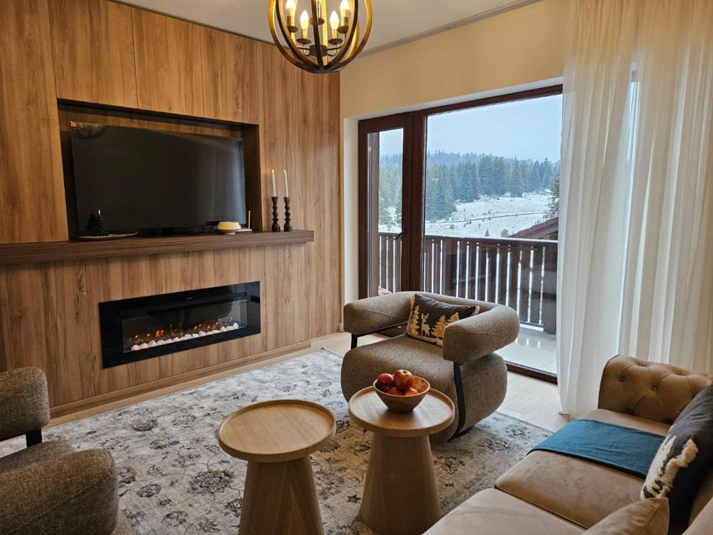 a living room with a fireplace and a tv at Mountain Whisper Chalet in Braşov