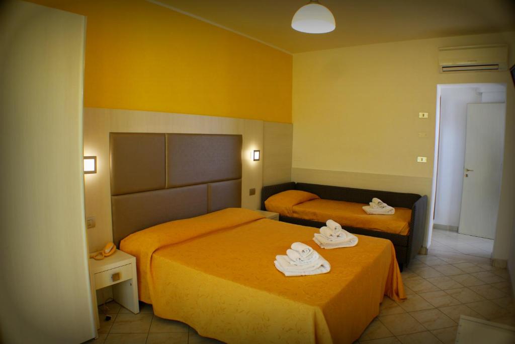 ベッラーリア・イジェア・マリーナにあるHotel Adriaのホテルルーム ベッド2台(タオル付)