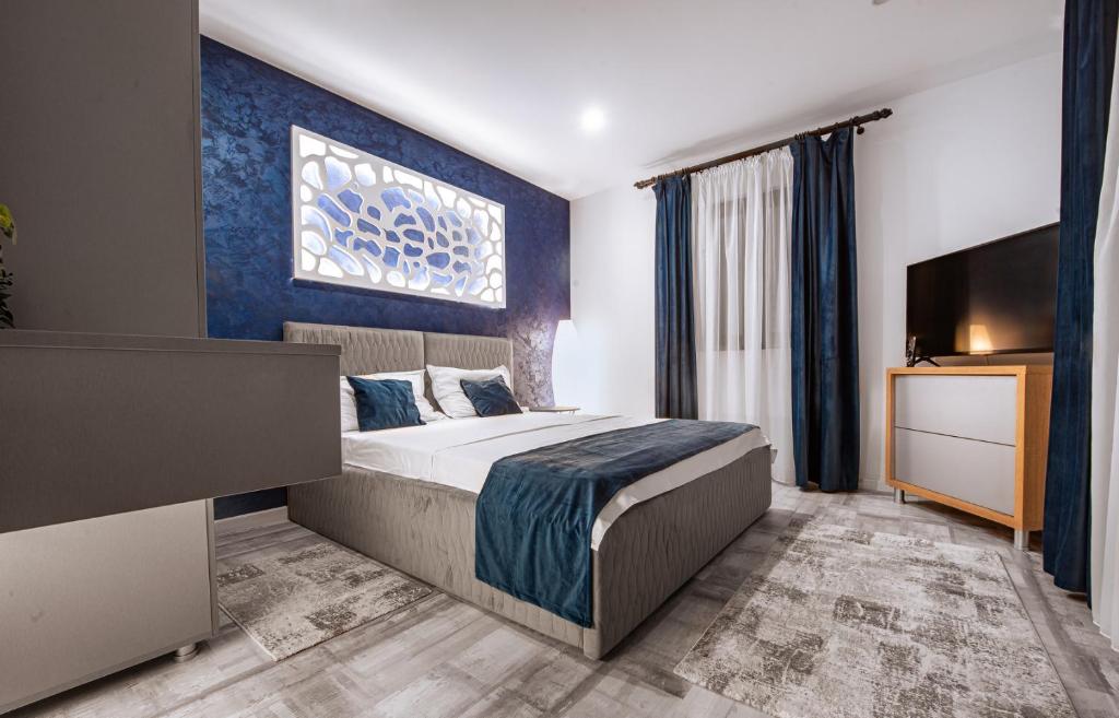a hotel room with a bed and a tv at Vila H2O in Mangalia