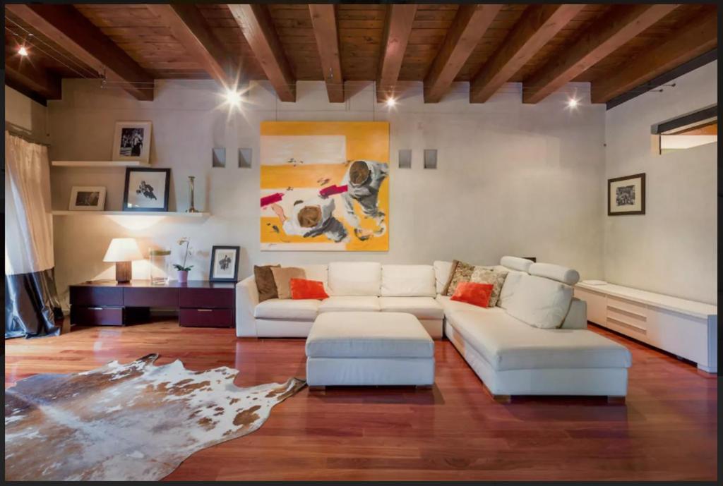 ヴェローナにあるPorta Vittoria Apartmentのリビングルーム(白いソファ2台、テーブル付)
