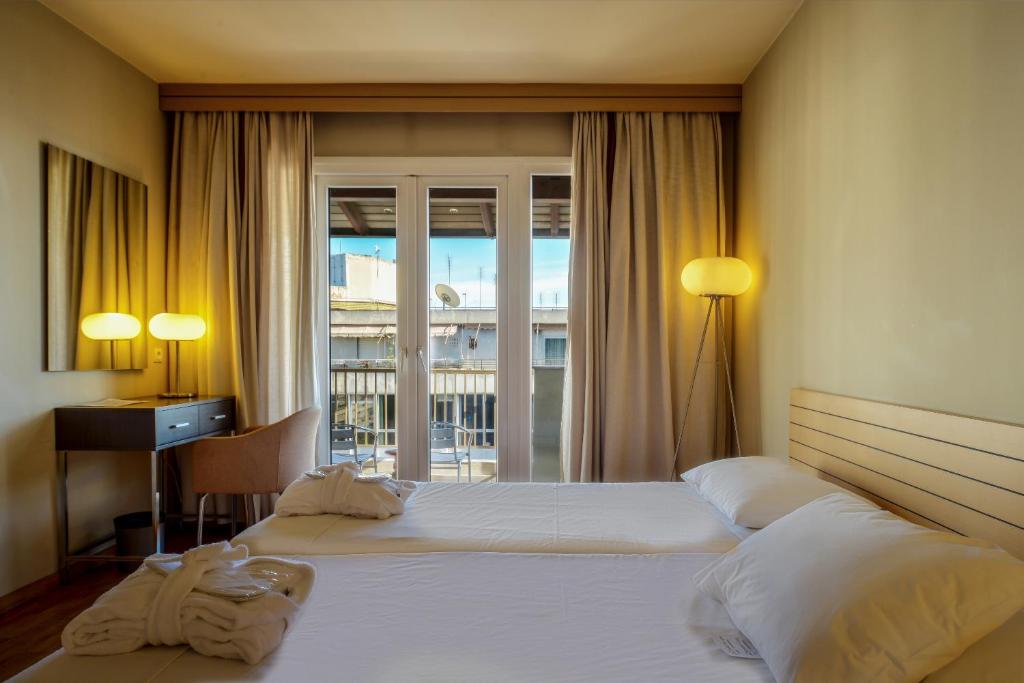 Łóżko lub łóżka w pokoju w obiekcie Astoria Hotel Thessaloniki