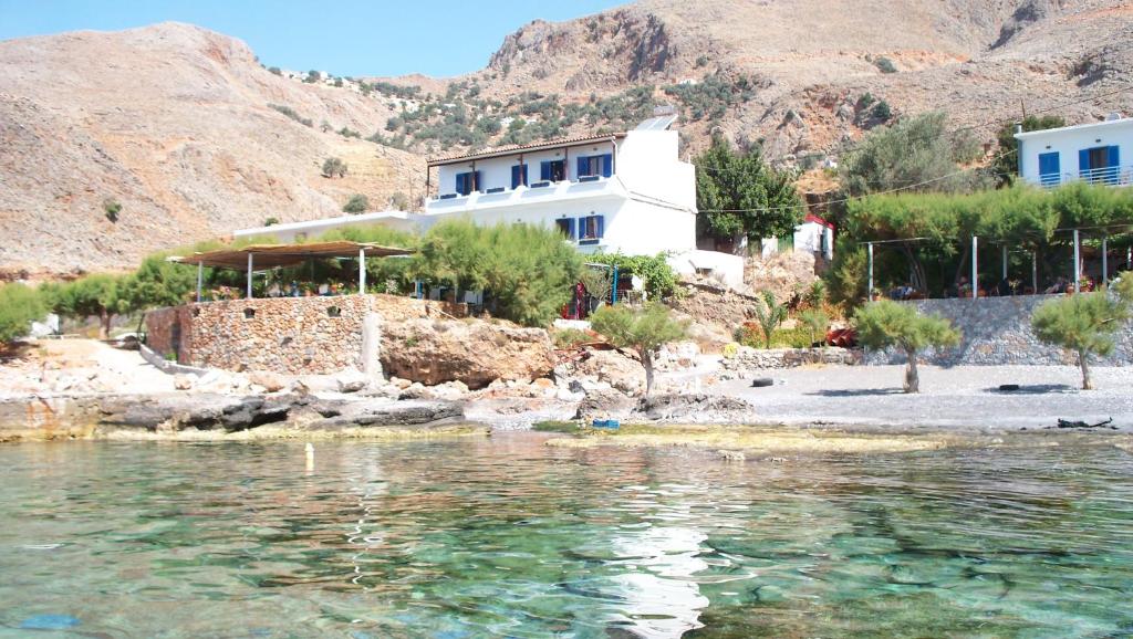 a house on the shore of a body of water at Taverna Akrogiali in Loutro