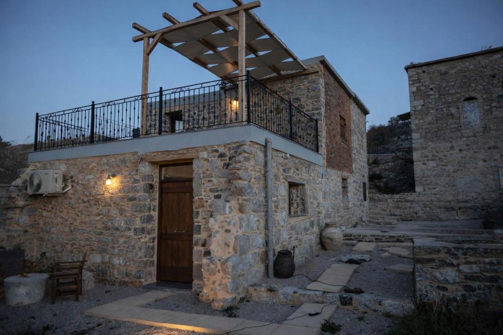 a stone building with a balcony on top of it at Stone Olympi Lodges - Chios Cozy Hideaways in Olýmpoi