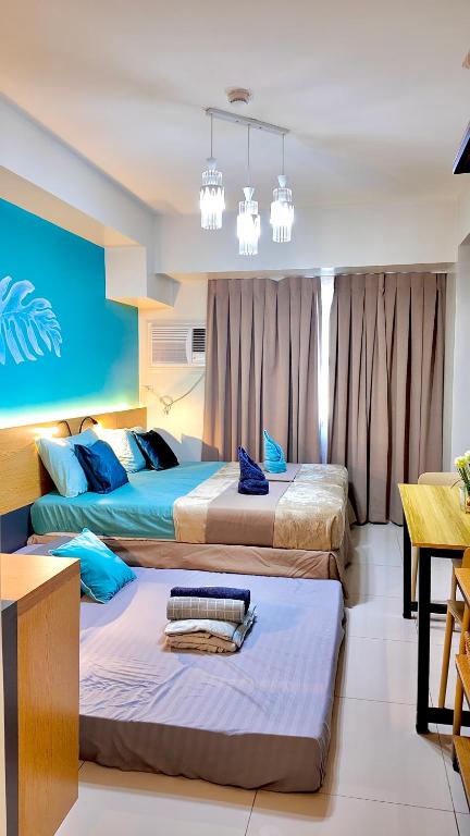 a bedroom with three beds in a room at Horizons 101-Premium Studio 42J in Cebu City