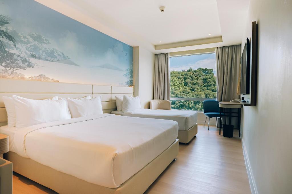 a hotel room with two beds and a window at Cititel Express Kota Kinabalu in Kota Kinabalu