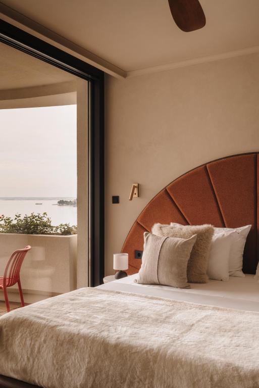 a bedroom with a large bed with a large window at Hotel Kali in Kali