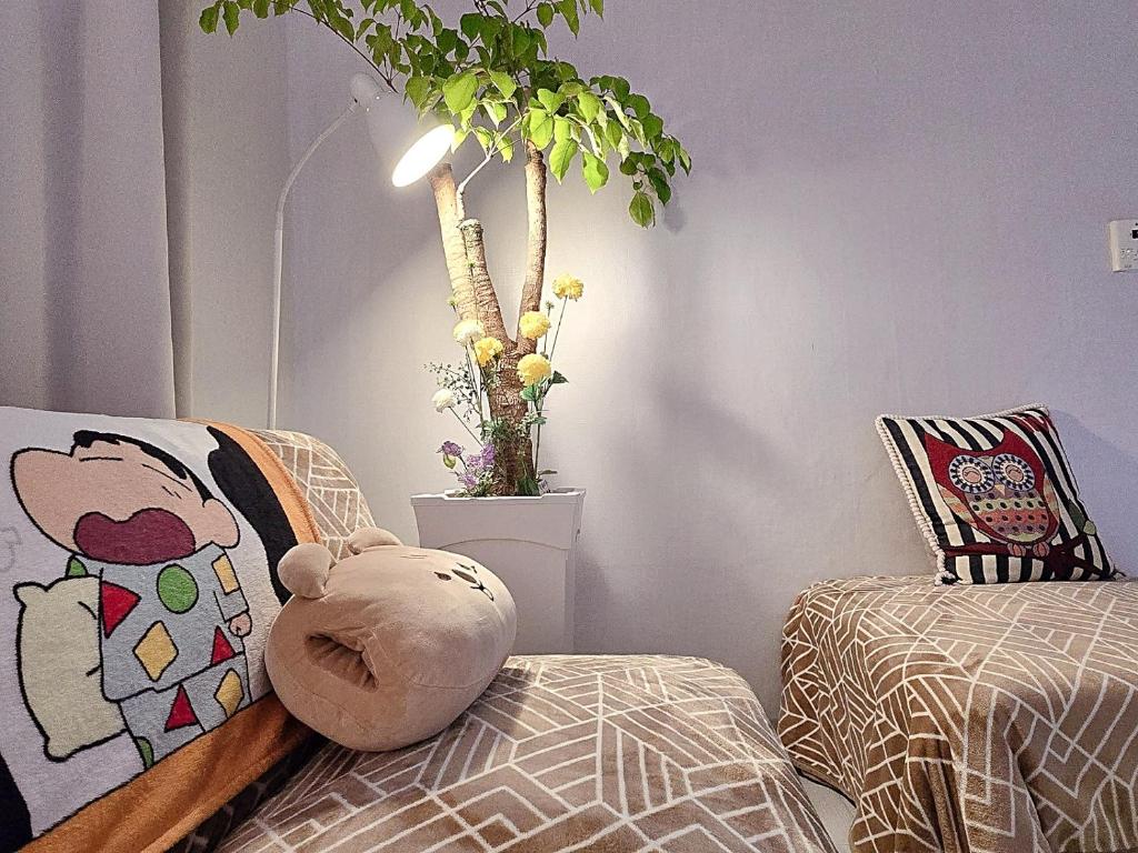 a stuffed teddy bear sitting on a bed next to a plant at Your Stay in Seoul