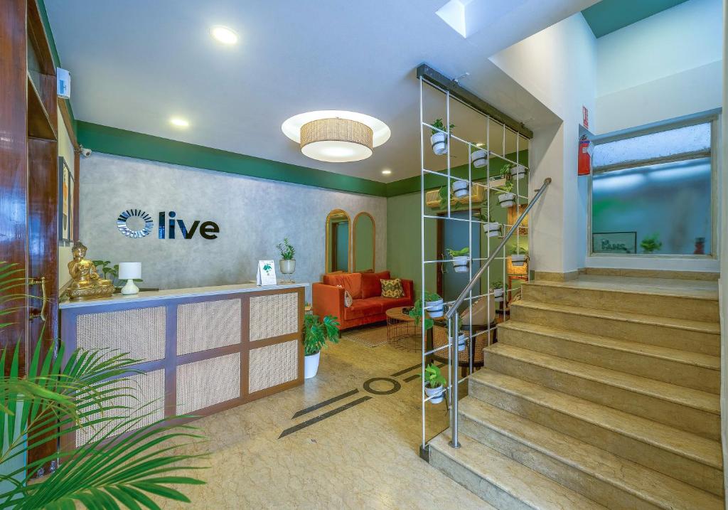 a lobby with stairs and a red couch at Olive Zip Rest House Road by Embassy Group in Bangalore
