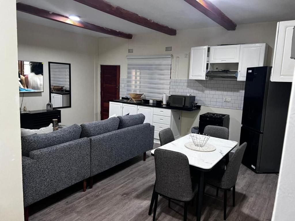 a living room with a couch and a table and a kitchen at 6ALouieVille in Lusaka