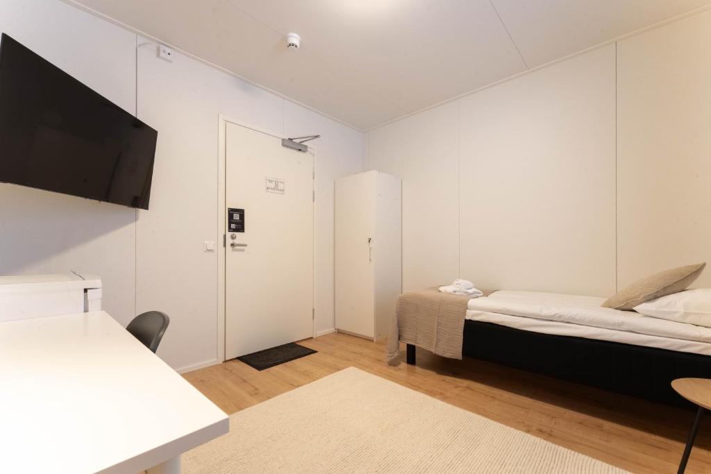 a small bedroom with a bed and a tv at LODGE Hostel Ylläs in Äkäslompolo