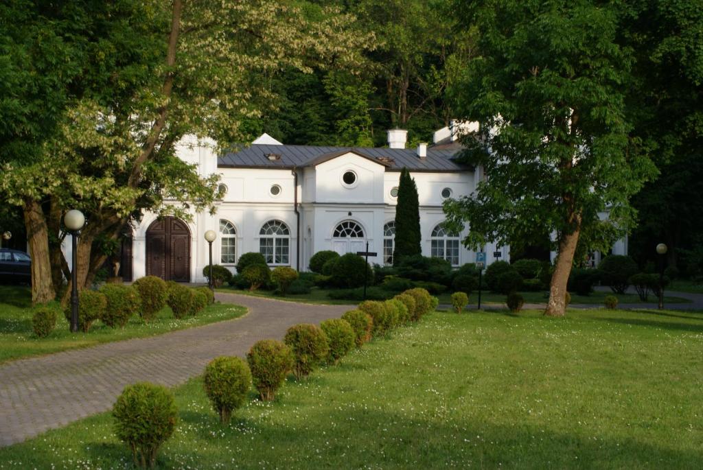 a white house with a driveway in front of it at Roskosz Zespół Dworsko Parkowy in Biała Podlaska