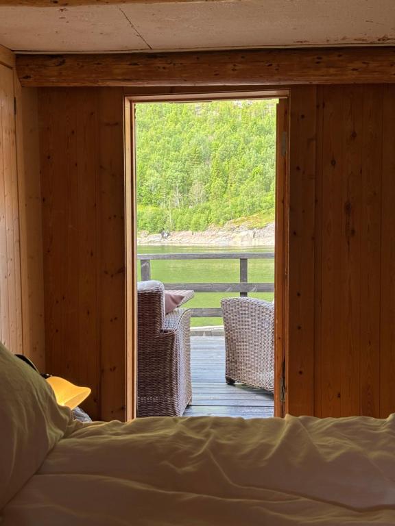a bedroom with a door open to a porch with a view at Brygge Sjøgata in Mosjøen