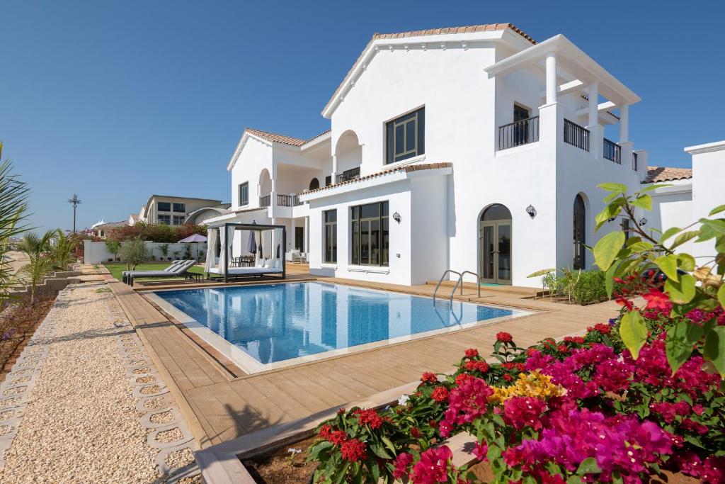 a villa with a swimming pool and flowers at Maison Privee - Villa on Beach with Private Pool The Palm Jumeirah in Dubai