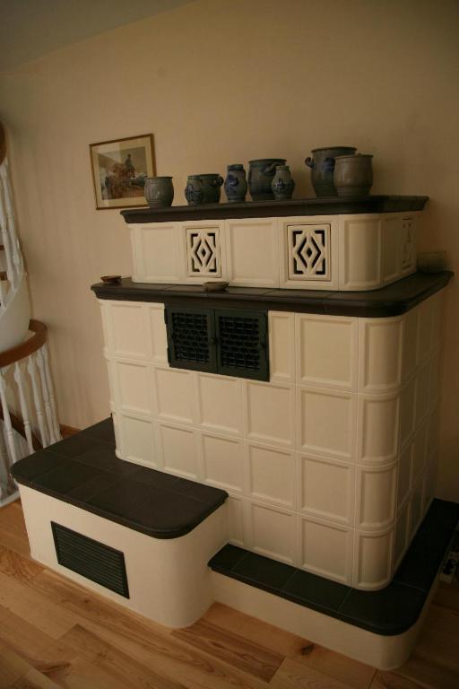 a white fireplace with pots on top of it at Les Chambres du Beau Regard in Villé