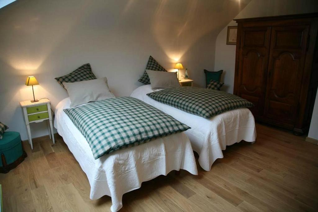 two beds sitting next to each other in a bedroom at Les Chambres du Beau Regard in Villé