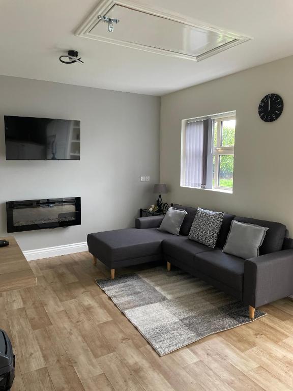 a living room with a couch and a tv at Greenway Cottage in Baltonʼs Cross Roads