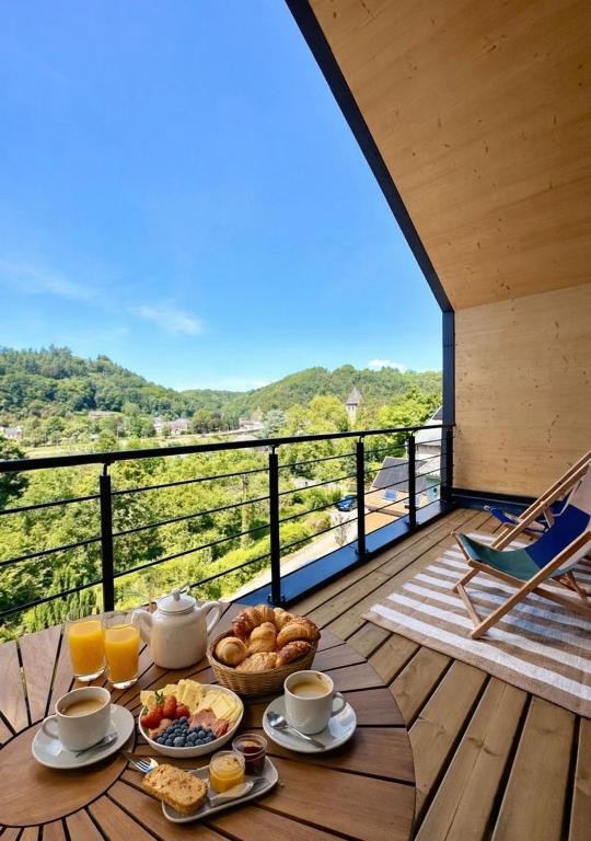 a breakfast table on a deck with a view at Meuse Cottage in Hastière-par-delà