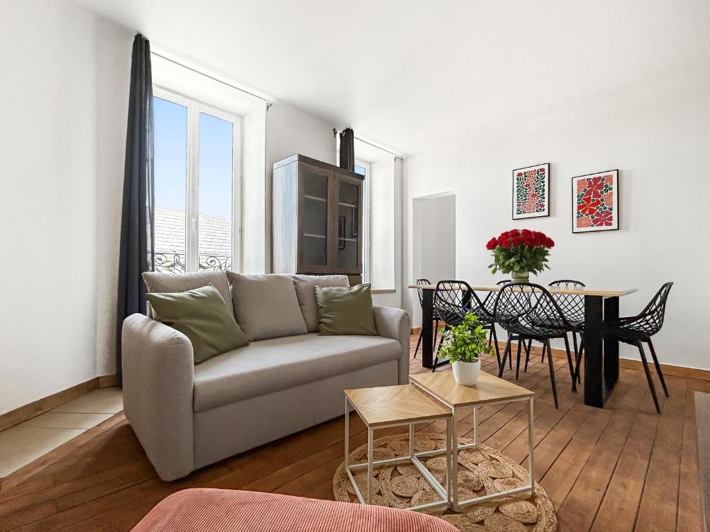 a living room with a couch and a table at Appartement moderne et lumineux avec parking privé in Vierzon