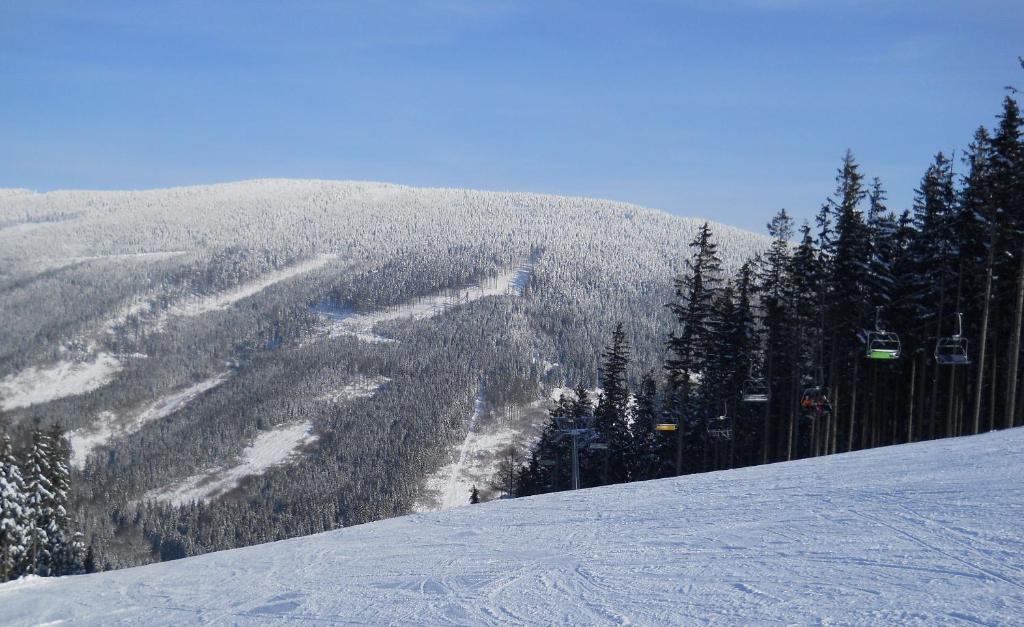 einen schneebedeckten Berg mit einem Skilift in der Ferne in der Unterkunft Apartments Světluška in Loučná nad Desnou