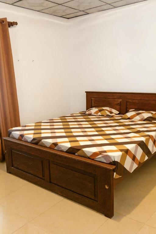 a bed with a wooden frame in a room at Green Serenity Villa in Ahangama