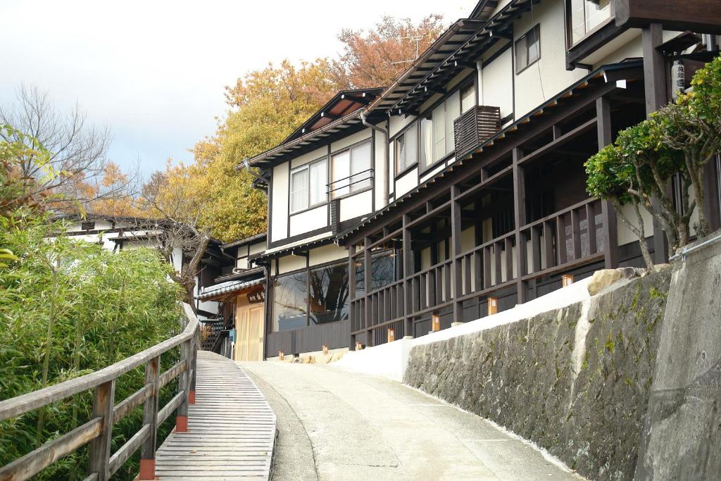 a building with a wooden walkway in front of it at Hidatakayama Futarishizuka Hakuun in Takayama