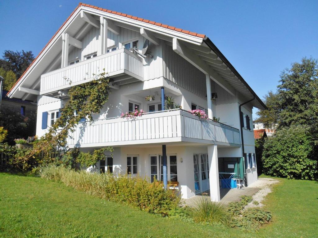 Casa blanca con balcón y césped en Ferienwohnung Rath en Oberreute