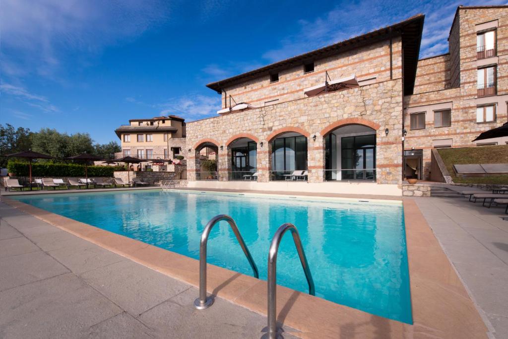 una piscina di fronte a un edificio di CDH Hotel Radda a Radda in Chianti