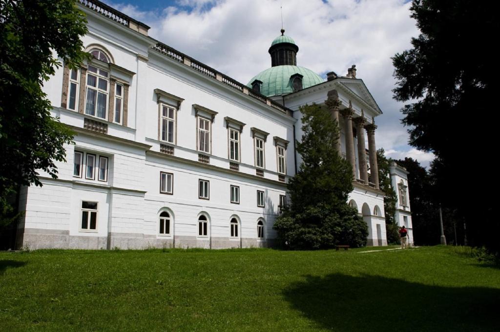 a large white building with a green dome on top at Hotel Zámok Topoľčianky in Topoľčianky