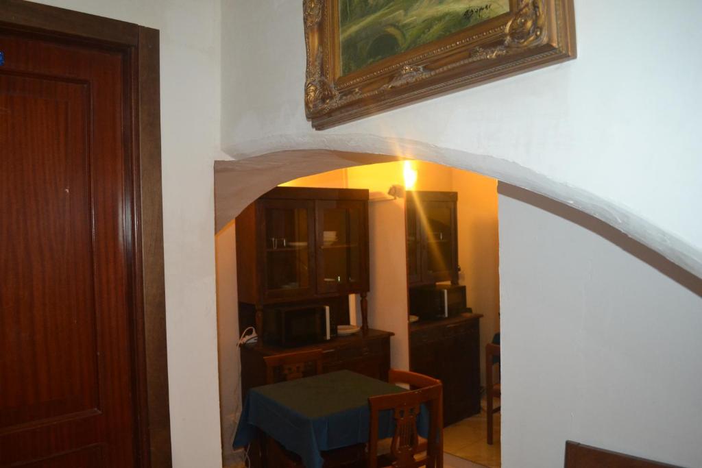 Suites Imperiali Guest House في روما: ممر مع طاولة وصورة على الحائط