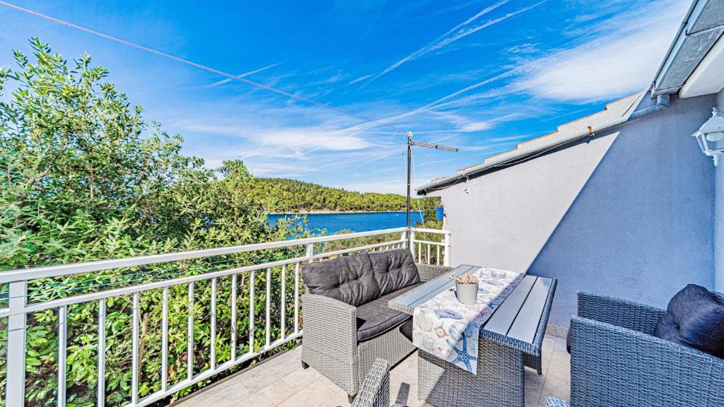 a balcony with a table and chairs on a building at Apartman Roza 2 by Villas Guide in Vela Luka