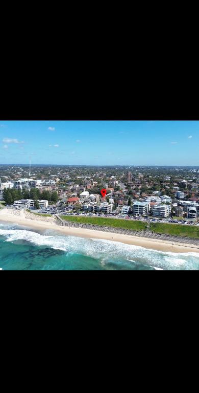 a view of a beach with buildings and the ocean at Top Location Beachside Apartment in Cronulla