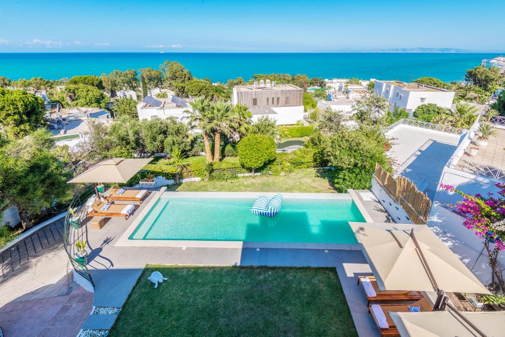 an aerial view of a swimming pool and the ocean at Villa Verde Azura in Bin Rhilouf