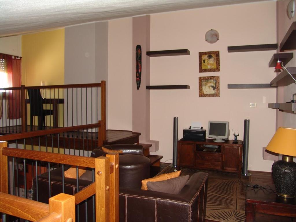 un soggiorno con divano, sedia e scrivania di Su Bellixeddu a Iglesias