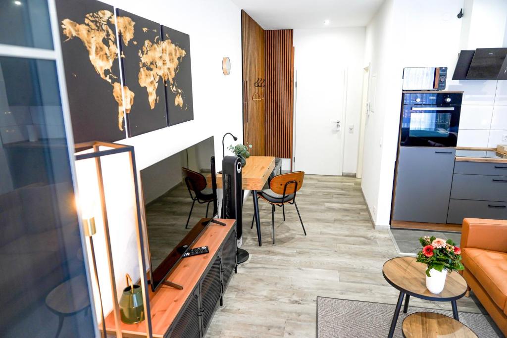 a living room with a table and chairs and a kitchen at Apart4me Style Apartment Geislingen zentral mit Parkplatz in Geislingen an der Steige