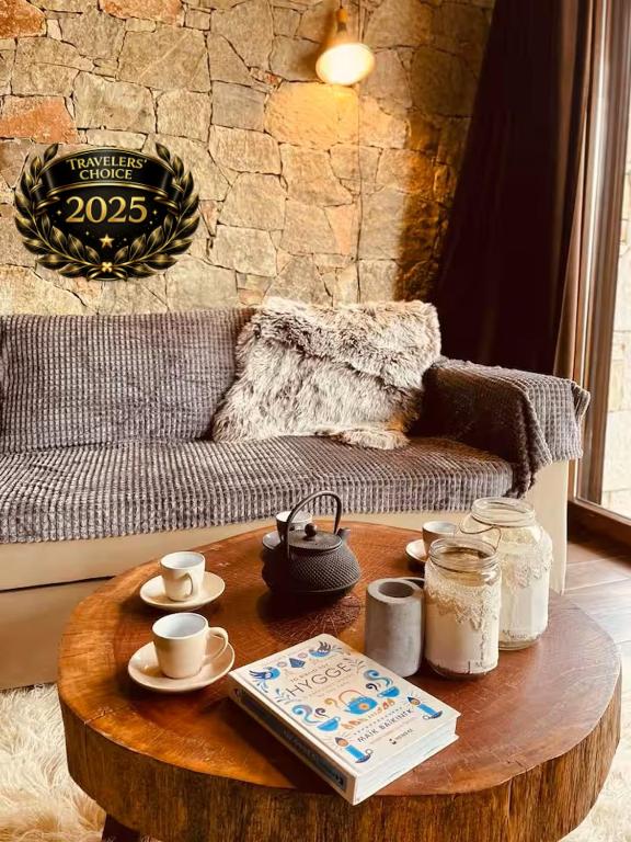 stolik kawowy w salonie z kanapą w obiekcie Pinecone Lodge, Eptalofos River Garden Chalet w mieście Eptalofos
