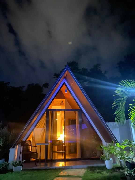 a small house with a large glass door at night at Grand Cabins in Panglao Island