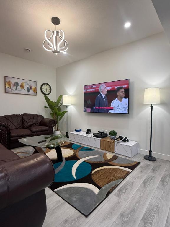 a living room with a couch and a flat screen tv at Maxti Guest Suite, Northwest Calgary in YYC