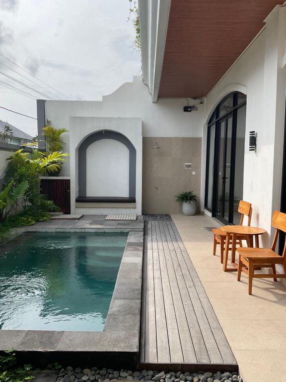 a house with a swimming pool and a patio at Twin House Villa in Canggu